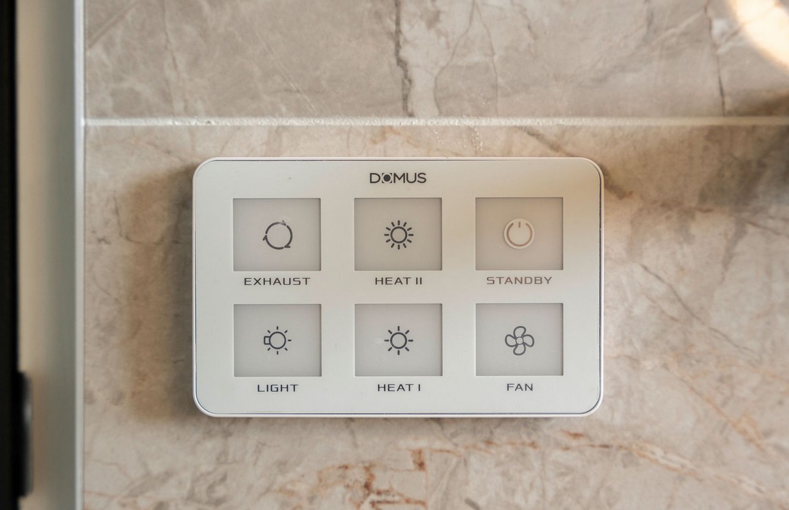 Wall switch panel for the bathroom exhaust fan, heat lamps and light on marble look tiles